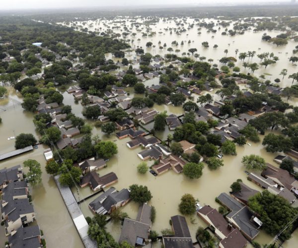 FILE - In this Aug. 29, 2017, file photo, water from Addicks Reservoir flows into neighborhoods from floodwaters brought on by Tropical Storm Harvey in Houston. Harris County commissioners have voted to ask the federal government for a $17 million grant to purchase 104 homes at the highest risk of flooding. The decision came even as more than 1,000 residents have called the Flood Control District in recent days to request buyouts of their Hurricane Harvey flood-damaged homes. (AP Photo/David J. Phillip, File)